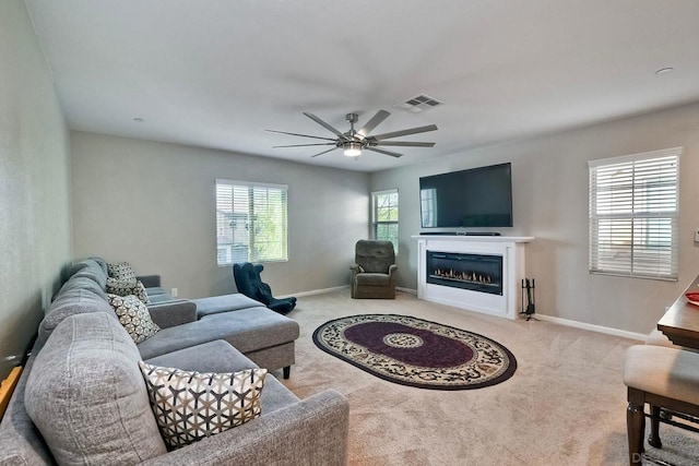 carpeted living room with ceiling fan and plenty of natural light