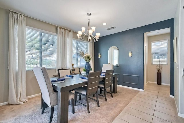 dining area featuring light carpet and a notable chandelier