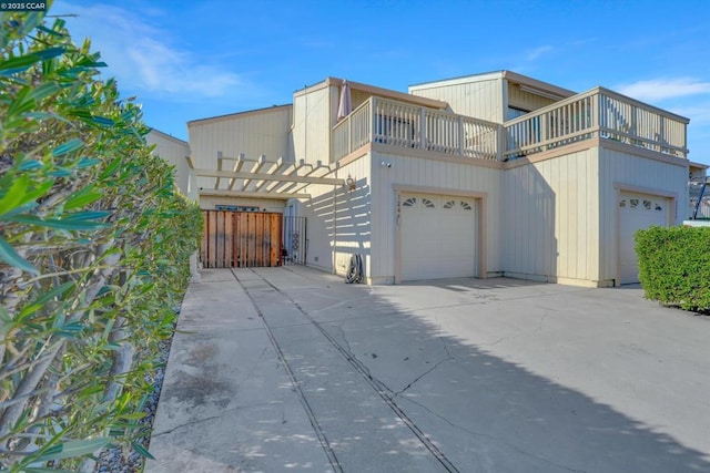 view of side of home with a garage and a balcony