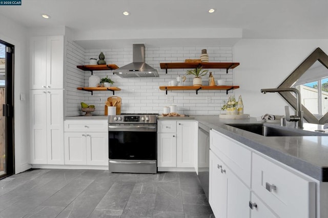 kitchen with stainless steel appliances, wall chimney exhaust hood, white cabinets, and sink