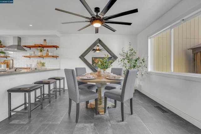 dining room with ceiling fan and sink