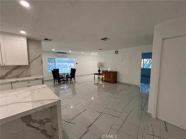 living room with plenty of natural light and a wall mounted air conditioner