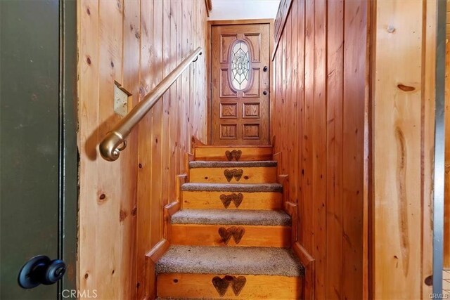 stairway with a skylight and wooden walls