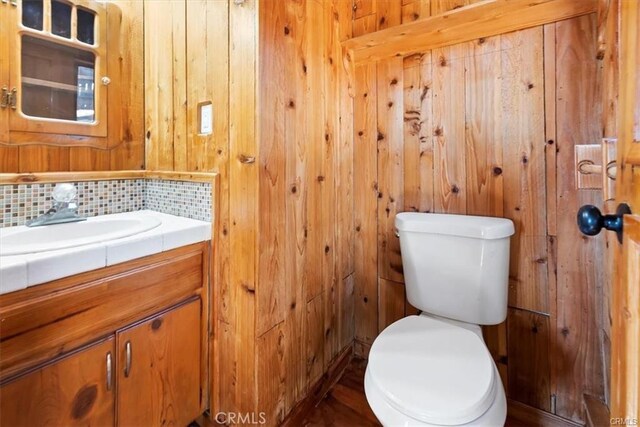 bathroom with backsplash, vanity, and toilet