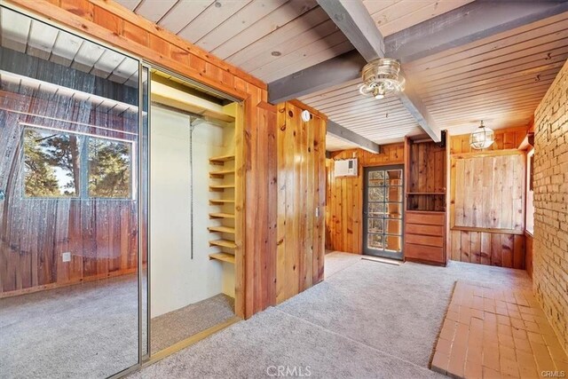 interior space with wooden walls, beamed ceiling, and wood ceiling