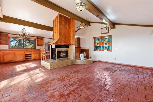 unfurnished living room with vaulted ceiling with beams, ceiling fan with notable chandelier, and a brick fireplace