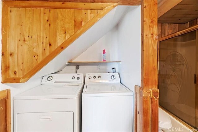 laundry room featuring washer and clothes dryer and wood walls