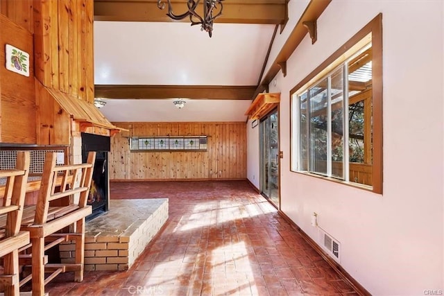 hallway with beam ceiling and wood walls