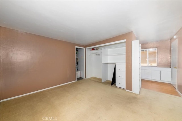 unfurnished bedroom with a closet and light colored carpet