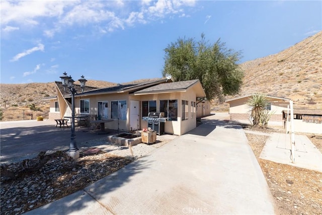 view of front of house with a patio area and a mountain view