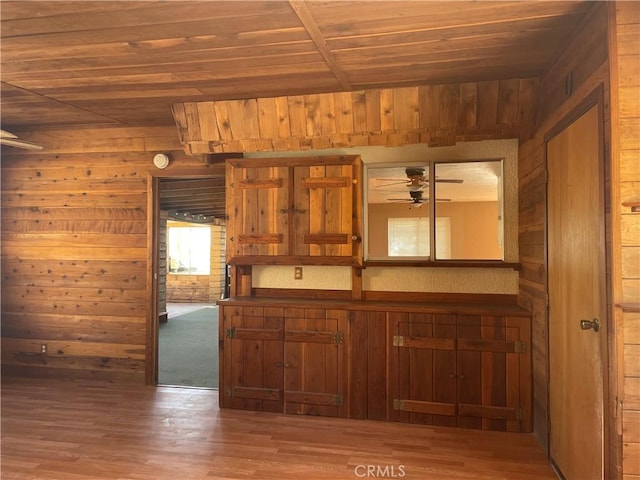 kitchen with ceiling fan, wood-type flooring, wood ceiling, and wooden walls