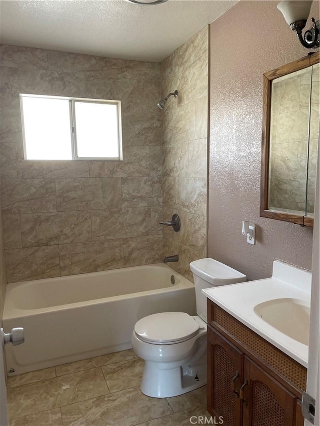 full bathroom featuring toilet, tiled shower / bath combo, vanity, and a textured ceiling