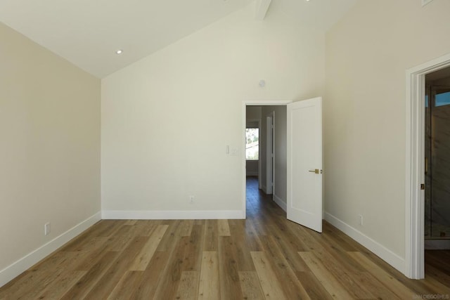 unfurnished room with light wood-type flooring, high vaulted ceiling, and beamed ceiling