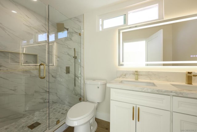 bathroom with toilet, an enclosed shower, and vanity