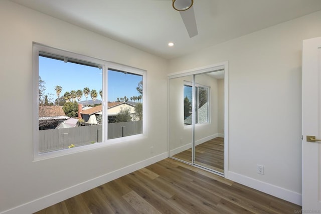 unfurnished bedroom with dark hardwood / wood-style floors and a closet