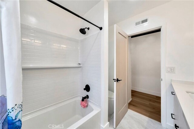 bathroom featuring wood-type flooring, vanity, and shower / bath combo with shower curtain