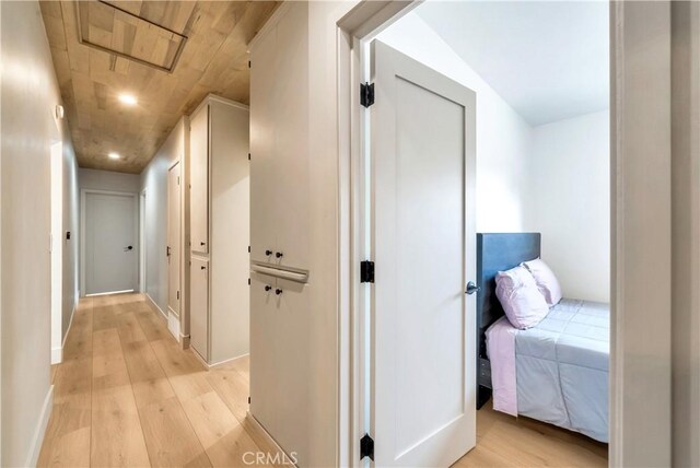 corridor with light wood-type flooring and wooden ceiling