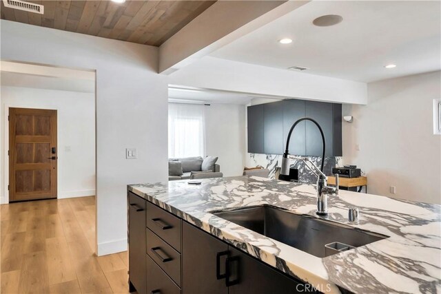 kitchen with light hardwood / wood-style floors, wooden ceiling, light stone countertops, beam ceiling, and sink