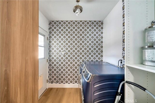 washroom with washing machine and clothes dryer and hardwood / wood-style flooring