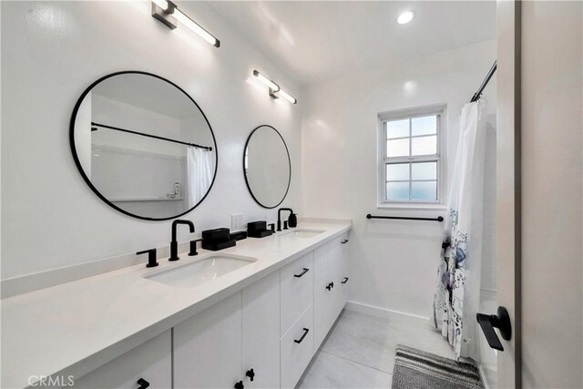 bathroom featuring tile patterned flooring, walk in shower, and vanity