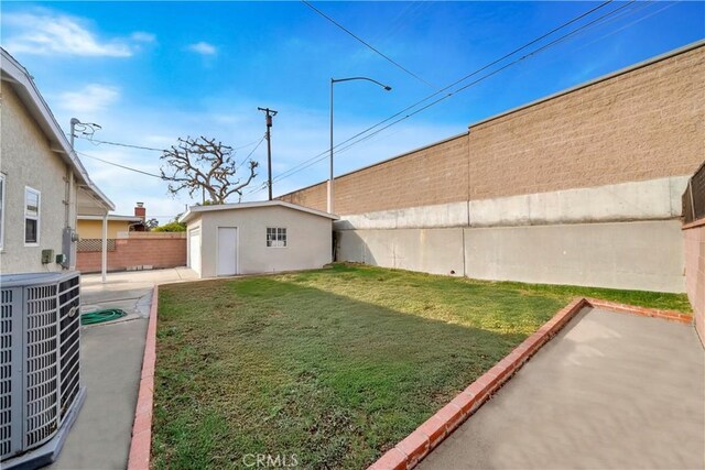 view of yard featuring an outbuilding, cooling unit, and a patio