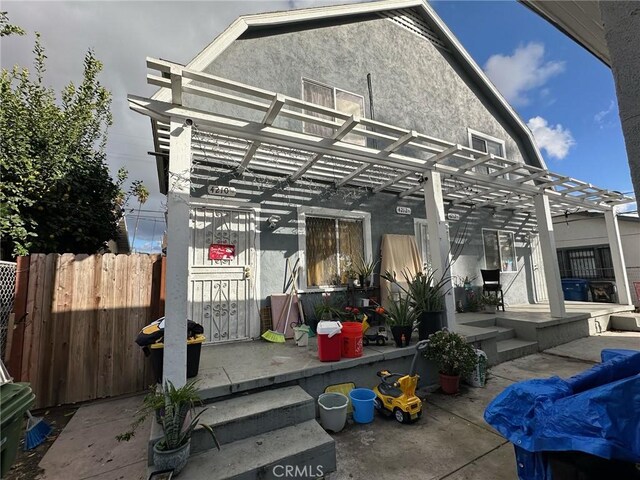 4210 Woodlawn Ave, Los Angeles, CA 90011 - rear view of house featuring a pergola, a patio, and stucco siding