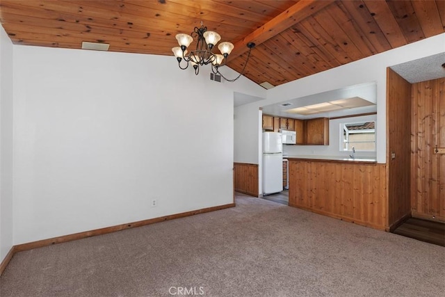 unfurnished living room featuring an inviting chandelier, wood ceiling, carpet floors, and lofted ceiling with beams