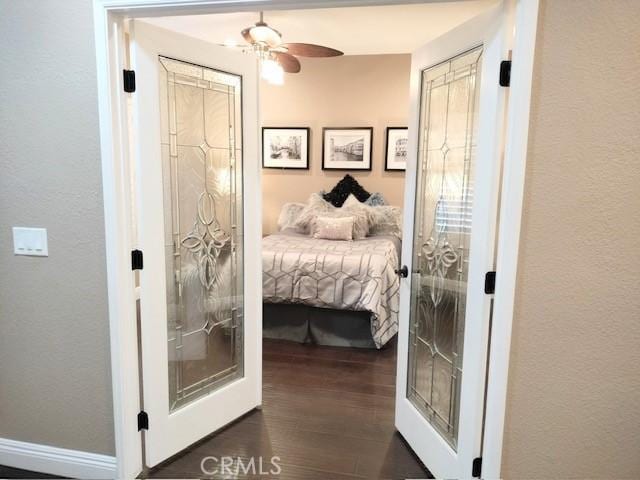 bedroom with dark wood-type flooring, ceiling fan, and french doors