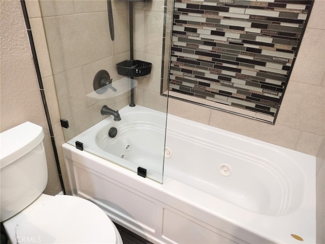 bathroom with toilet and tiled shower / bath combo