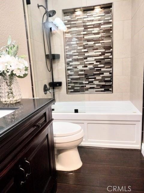 full bathroom featuring toilet, tiled shower / bath, vanity, and hardwood / wood-style flooring