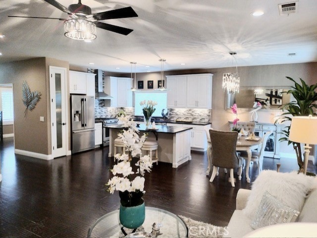 dining room featuring ceiling fan with notable chandelier and dark hardwood / wood-style floors