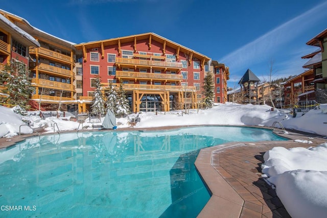 snow covered pool with a patio area