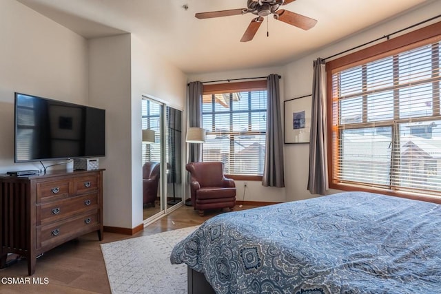 bedroom featuring multiple windows, light wood-type flooring, and ceiling fan