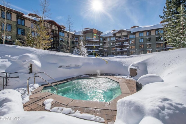 snow covered pool featuring a hot tub