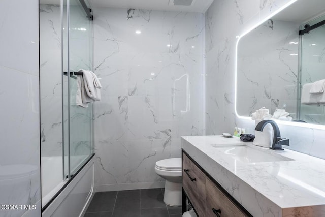 full bathroom with tile patterned flooring, vanity, toilet, and bath / shower combo with glass door