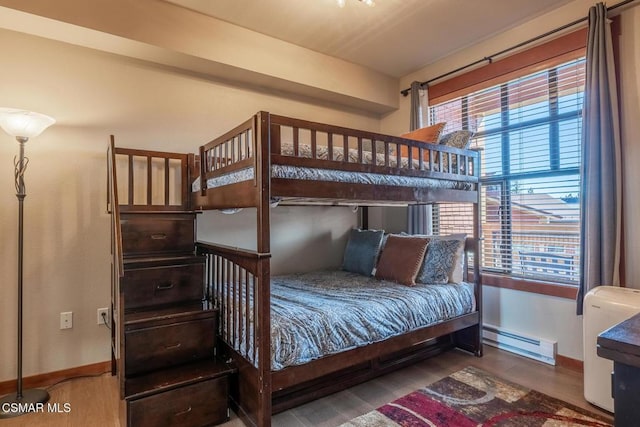 bedroom featuring baseboard heating and hardwood / wood-style flooring