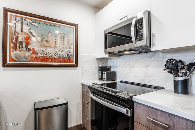 kitchen with decorative backsplash and electric range