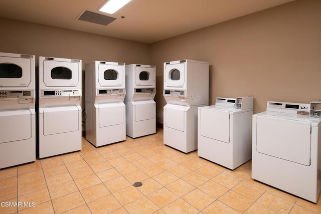 washroom featuring stacked washer / drying machine, light tile patterned flooring, and independent washer and dryer