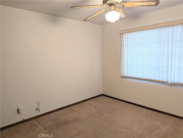 spare room featuring baseboards, a ceiling fan, and carpet flooring