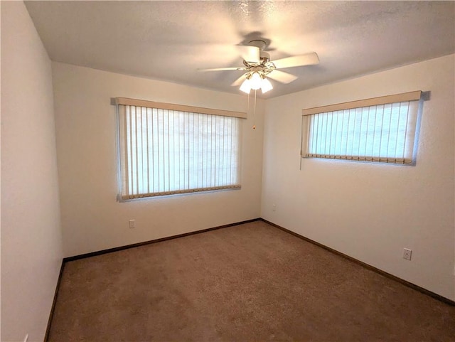 empty room featuring baseboards, a textured ceiling, ceiling fan, and carpet flooring