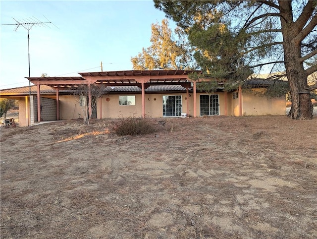 rear view of property featuring stucco siding