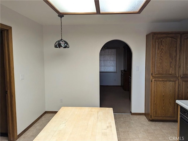 interior space featuring baseboards and arched walkways