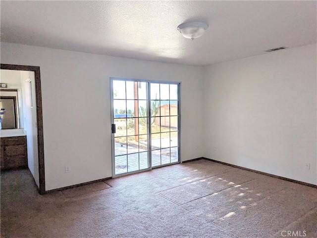 unfurnished room featuring a textured ceiling and carpet floors