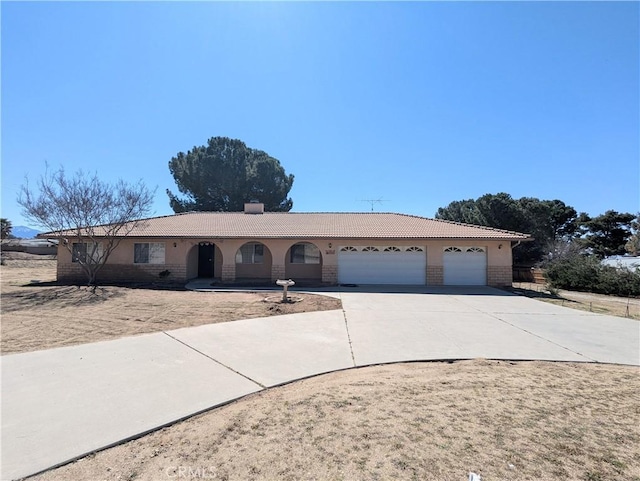 ranch-style home featuring stucco siding, concrete driveway, an attached garage, and a tiled roof