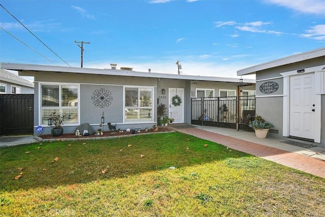 view of front of property with a front yard, fence, and stucco siding