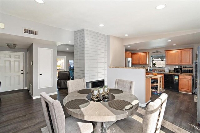 dining area featuring a fireplace and dark wood-type flooring