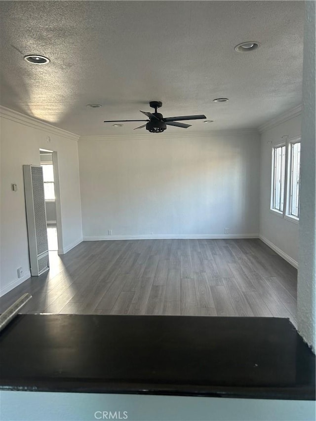 spare room with crown molding, a textured ceiling, and hardwood / wood-style flooring