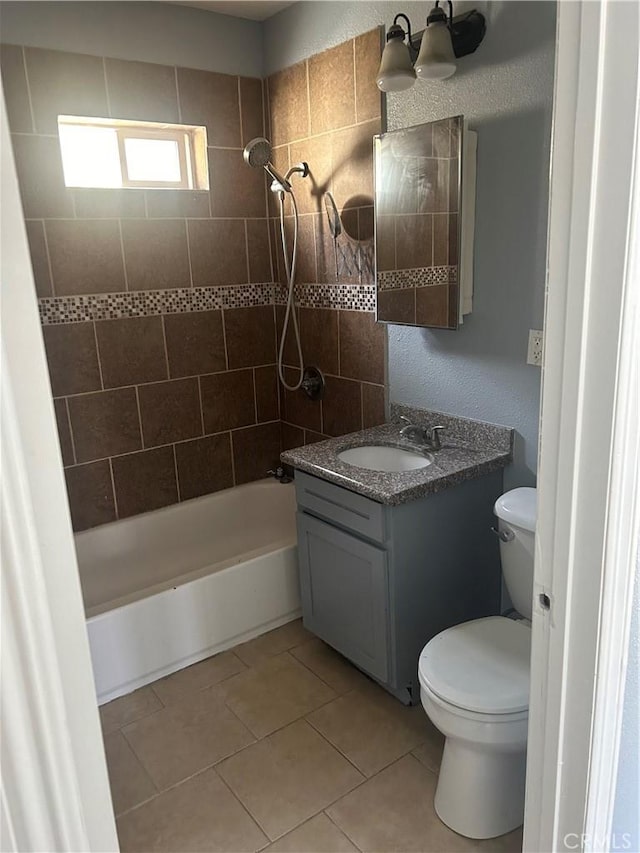 full bathroom featuring tile patterned floors, toilet, vanity, and tiled shower / bath