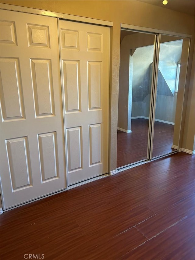 unfurnished bedroom with a closet and dark hardwood / wood-style flooring