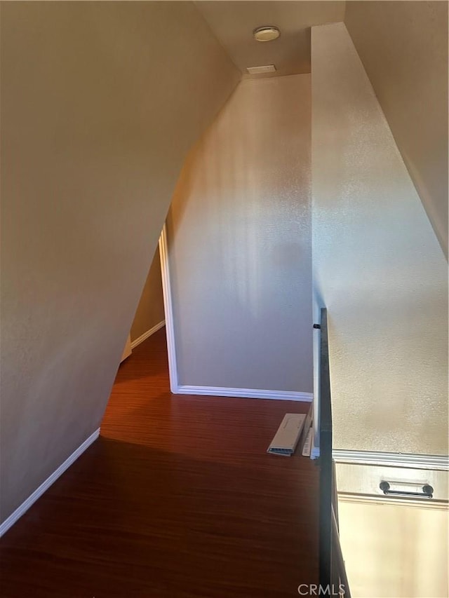 bonus room with vaulted ceiling and dark wood-type flooring